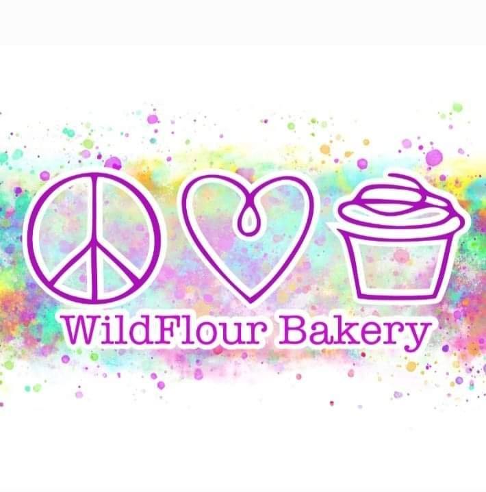 WildFlour Bakery logo — peace sign, heart, and cupcake over a purple, pink, and teal watercolor splatter